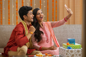 brother and sister taking a selfie with the happy mood 	