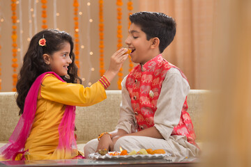 young sister giving sweets to her brother	