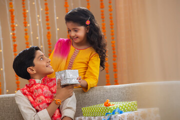 brother giving gift to his sister	