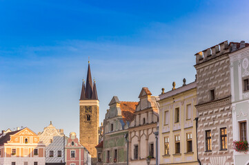 Obraz premium Church tower and old houses at the historic market square of Telc, Czech Republic