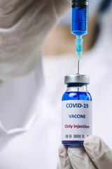 COVID-19 vaccine in researcher hands, unrecognizable female doctor holds syringe