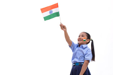 young school girl waving flag with flag drawn on her cheeks , independence day	