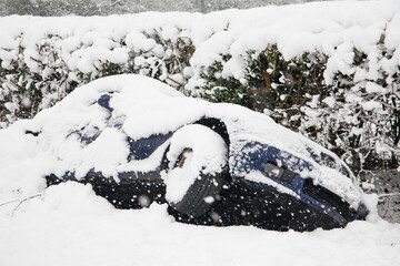 A car lies in a ditch having skidded off the road during heavy snowfall in Buckinghamshire, England