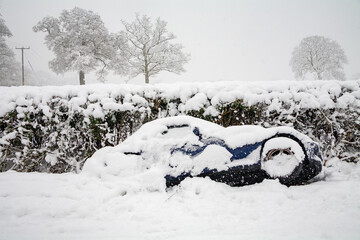A car lies in a ditch having skidded off the road during heavy snowfall in Buckinghamshire, England