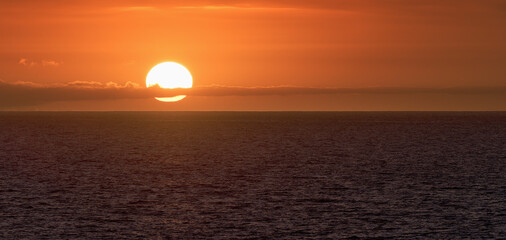 Sun is setting on horizon at sunset sunrise over sea or ocean. Tranquil sea ocean waves