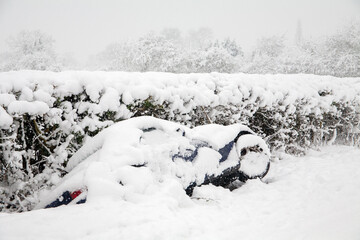 A car lies in a ditch having skidded off the road during heavy snowfall in Buckinghamshire, England