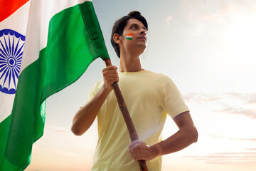 young man holding indian flag proudly, independence day	