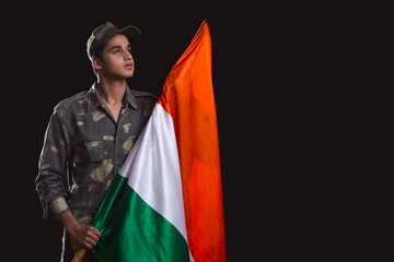 indian soldier holding national flag proudly, independence day	