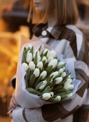 Woman holding big beautiful blossoming mono bouquet of fresh white tulips flowers. Fresh white...