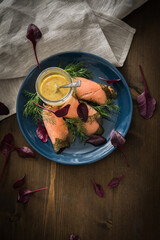 Gravlax Graved Lachs mit Rote Beete Blätter Salat, Dill, Rævesovs Senf Soße auf dunkel blau...