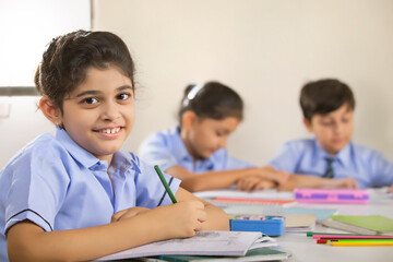 school girl sitting in class and smiling	