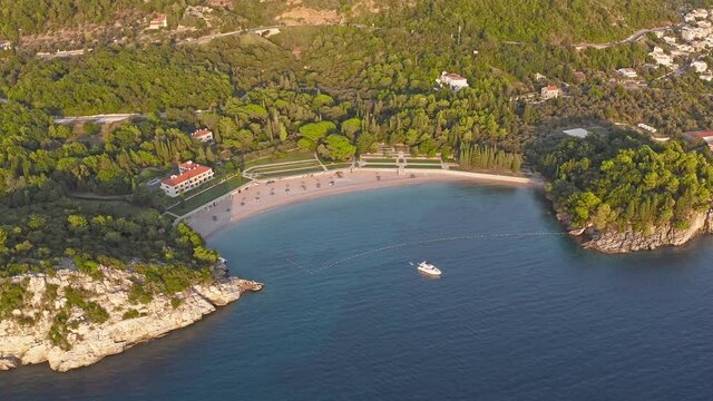 View on Milocer beach (Milocer Plaza) and Aman Villa Milocer (ex. Kralijicina Plaza), Montenegro. Sveti Stefan. Milocher. The beaches of the king and queen in Montenegro. Large white yacht in the bay