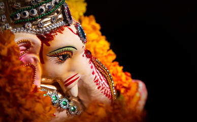 top shot of lord ganesha idol with flower garland	