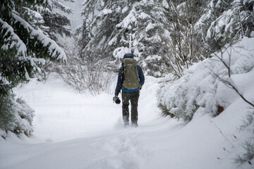 Fototapeta na wymiar Man hiking in the mountains with snow