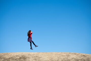 青空の下でジャンプする女の子