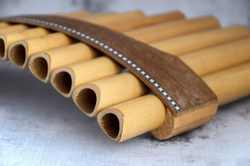 Close-up of woodwind instrument pan flute. Details of musical instruments, music. Selective focus, blurred background.