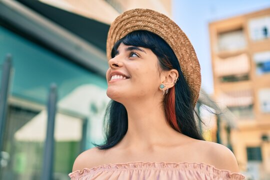 Young hispanic tourist girl wearing summer style walking at the city.