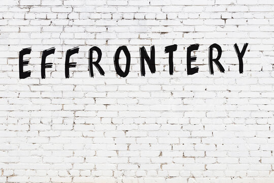 White wall with black paint inscription effrontery on it