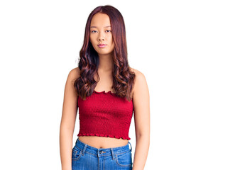 Obraz premium Young beautiful chinese girl wearing casual clothes relaxed with serious expression on face. simple and natural looking at the camera.