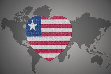 puzzle heart with the national flag of liberia on a world map background.