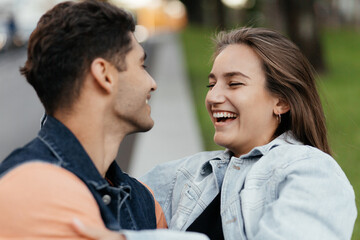 Young lovers in casual style having fun on the street. Man and woman laughing. Couple in love in the city. Urban lovestory