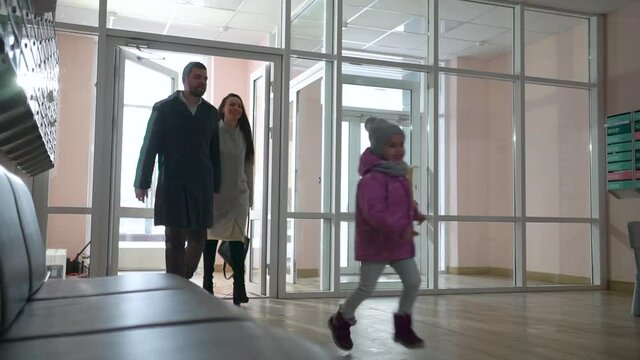 parents with a child enter the corridor of an apartment building