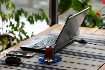 Working at home on a task, with mobile phone, tea and a computer
