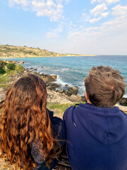 Fototapeta na wymiar Young couple enjoying a magnificent view on the rocky coast line on a sunny day outdoors, Cyprus