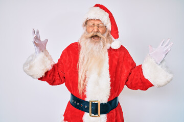 Old senior man with grey hair and long beard wearing santa claus costume with suspenders celebrating mad and crazy for success with arms raised and closed eyes screaming excited. winner concept