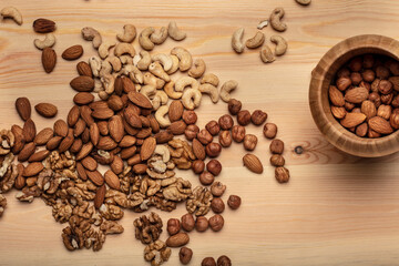 Mixed nuts in bowl on wooden background