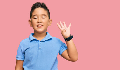 Little boy hispanic kid wearing casual clothes showing and pointing up with fingers number four while smiling confident and happy.