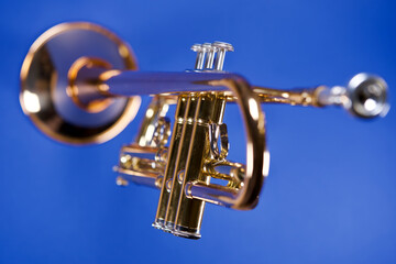 Obraz na płótnie Canvas Golden trumpet on blue background.