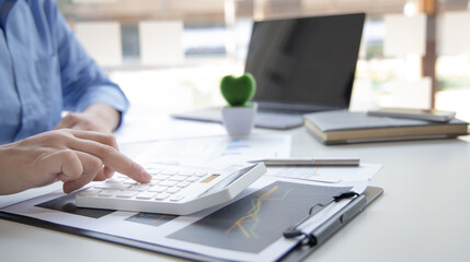 Fototapeta na wymiar Financial businessman calculating corporate income tax data And analyzing charts of financial stocks that are in good condition with growth and progress, Investment in finance and accounting.