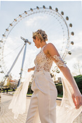 bride in wedding women's suit, background Ferris Wheel and nature