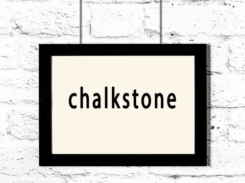 Black frame hanging on white brick wall with inscription chalkstone