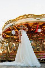 the bride is standing at full height near the carousel