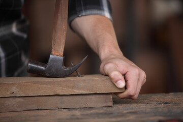 Carpenter, he is working in the workshop. Man at work on wood. Image of mature carpenter in the workshop, furniture making concept.