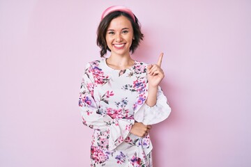 Young beautiful woman wearing casual clothes and diadem smiling happy pointing with hand and finger to the side