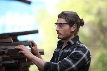 Carpenter, he is working in the workshop. Man at work on wood. Image of mature carpenter in the workshop, furniture making concept.