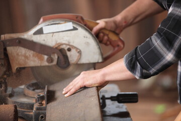 Carpenter, he is working in the workshop. Man at work on wood. Image of mature carpenter in the workshop, furniture making concept.