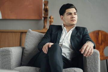 lawyer business man of Caucasian appearance in a business suit works. The stylish office sits on a comfortable chair. the work of an economist.
