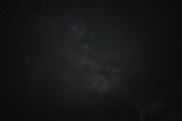 Stars in the night sky through the clouds on a summer night