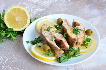 roasted fish with lemon olives and parsley on the beige background