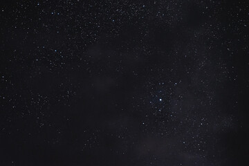 Fototapeta na wymiar Stars in the night sky through the clouds on a summer night