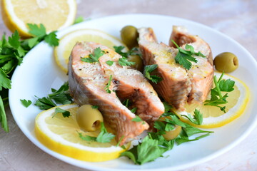 roasted fish with lemon olives and parsley on the beige background