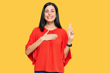 Beautiful young woman wearing casual clothes smiling swearing with hand on chest and fingers up,...