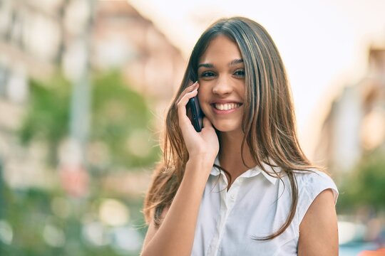Beautiful latin teenager girl smiling happy talking on the smartphone at the city.