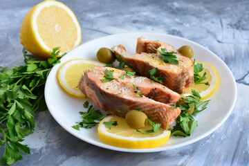 roasted fish with lemon olives and parsley on the beige background