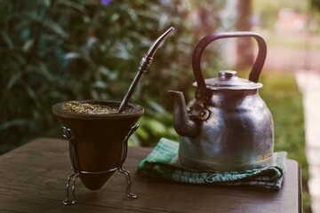 Bebiendo mate en el patio al atardecer. bebida típica de Argentina. Mate  pava tradicional sobre la mesa. © Daniel