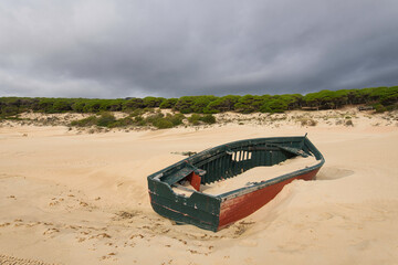 The fisherman boat abandoned in the dunes of Baelo Claudia near Tarifa, Spain, during quarantine...